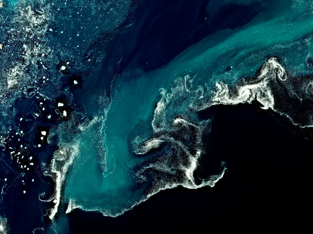 Groenland — la vague — Les courants autour de la glace tracent une vague blanche dans les bleus de l’eau.