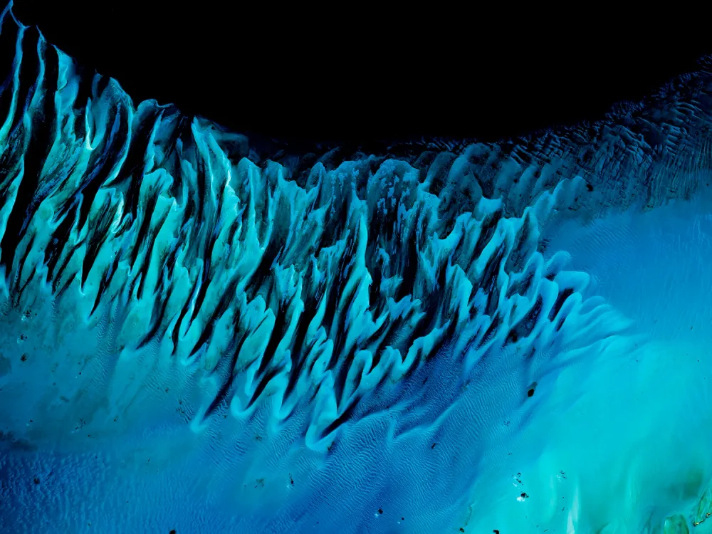 Les Bahamas — Des lignes et des ondulations turquoise s’avancent vers les profondeurs sombres de l’océan.