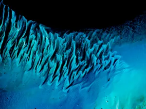 Les Bahamas — Des lignes et des ondulations turquoise s’avancent vers les profondeurs sombres de l’océan.