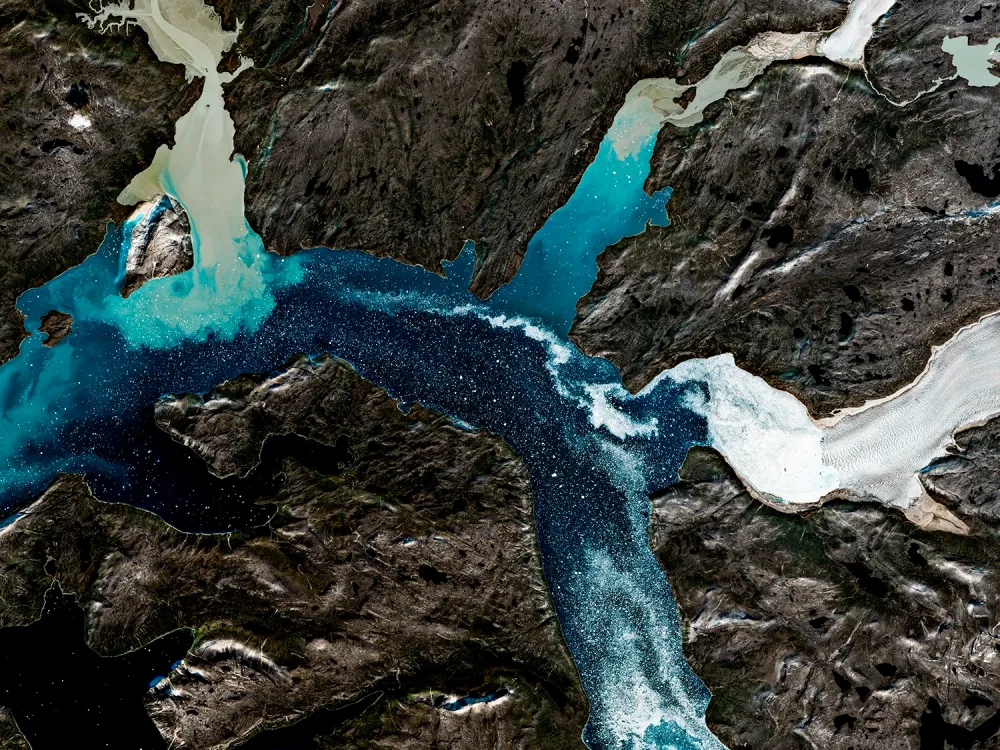 Les glaciers du Groenland — Le glacier et les eaux bleues du détroit de Davis se répondent au milieu de terres sombres.