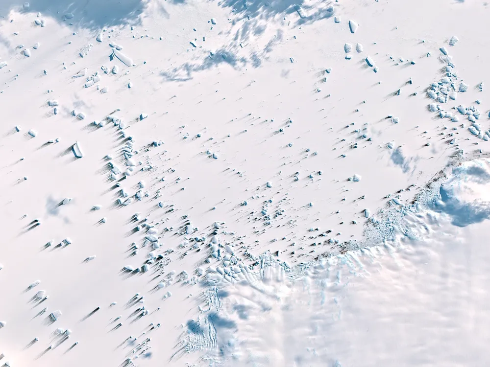 Le Continent Blanc — Un paysage blanc ponctué d’ombres bleues et de reliefs, dans un équilibre presque minimaliste.